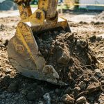 Pala de excavadora levantando tierra en un sitio de construcción