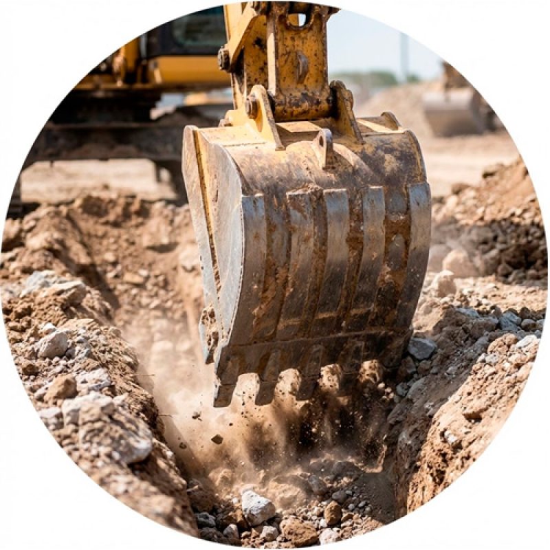Retroexcavadora cavando una zanja en un terreno arenoso durante una obra de construcción.